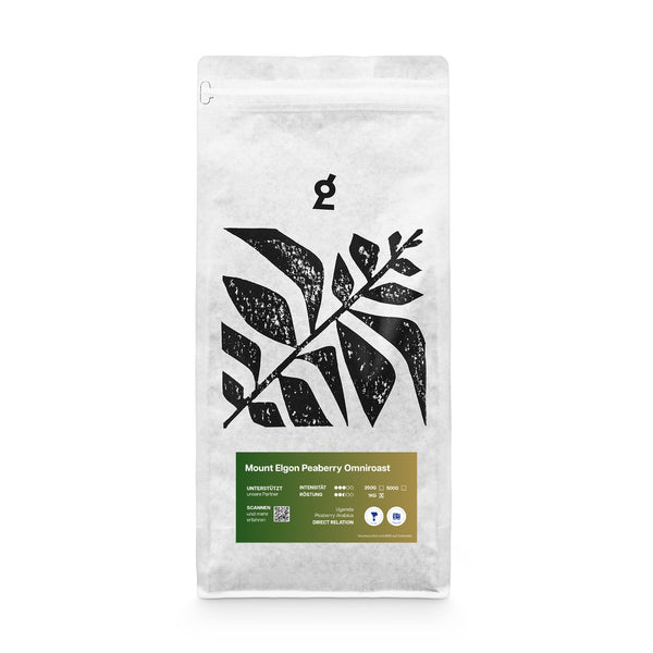Verpackung des Mount Elgon Peaberry Omni roast Kaffees in Weiß mit schwarzem botanischem Blätter-Logo. Das grüne Etikett zeigt Details wie Herkunft Uganda, Röstintensität und das Direct Relation Siegel.